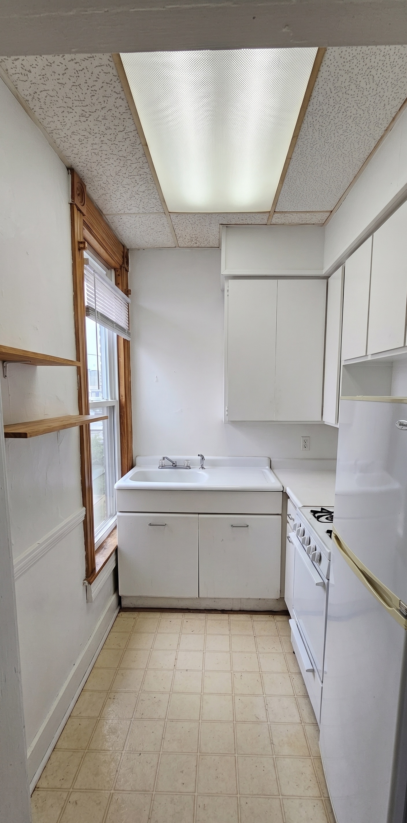 306 Unit 2 Kitchen &mdash; galley kitchen with white cabinets and gas stove